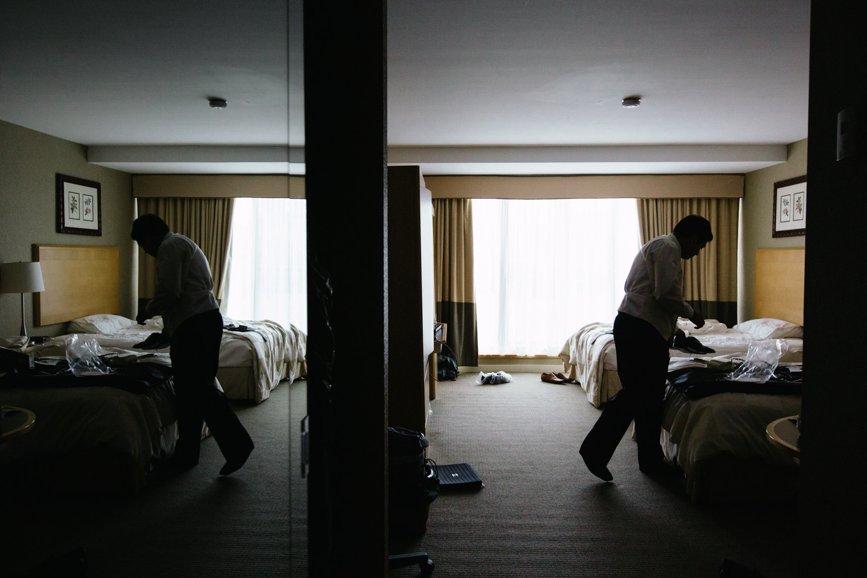 Groom preparing in a messy hotel room at Kingbridge Centre.