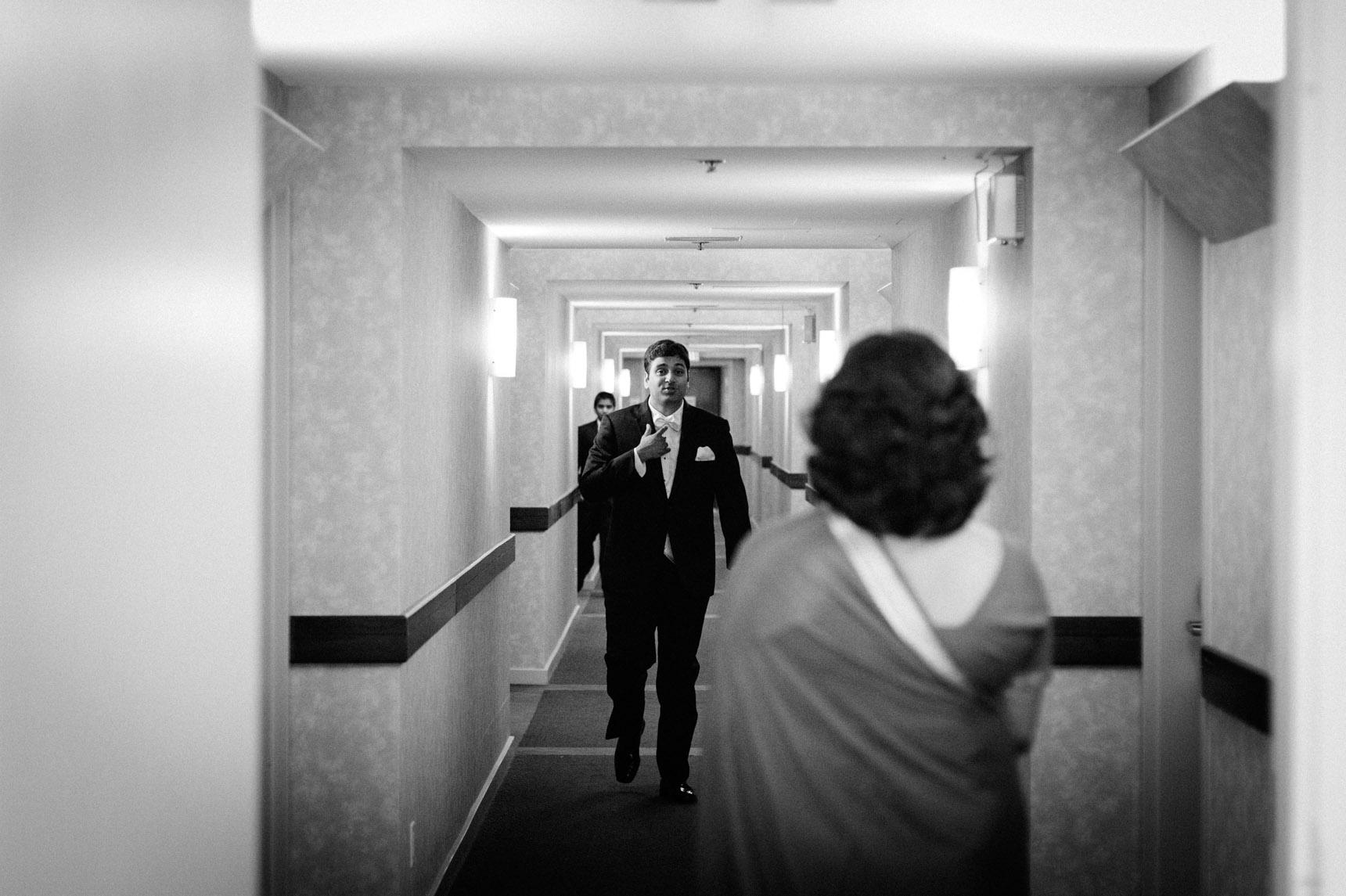 Groom walks down hallway of Kingbridge Centre hotel.