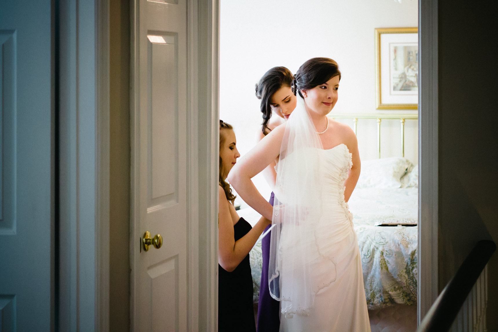 Bride and bridesmaids in bedroom.