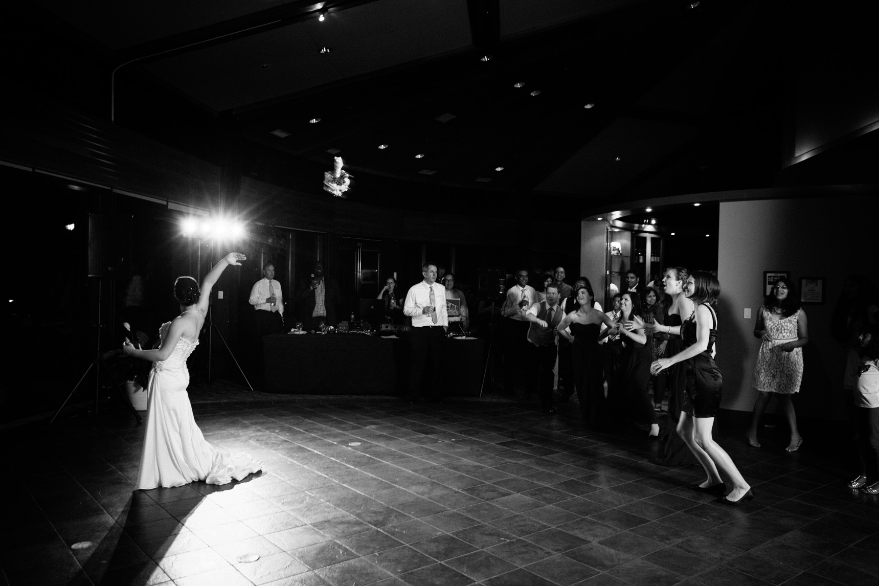 Bride tosses her flower bouquet from the dance floor.