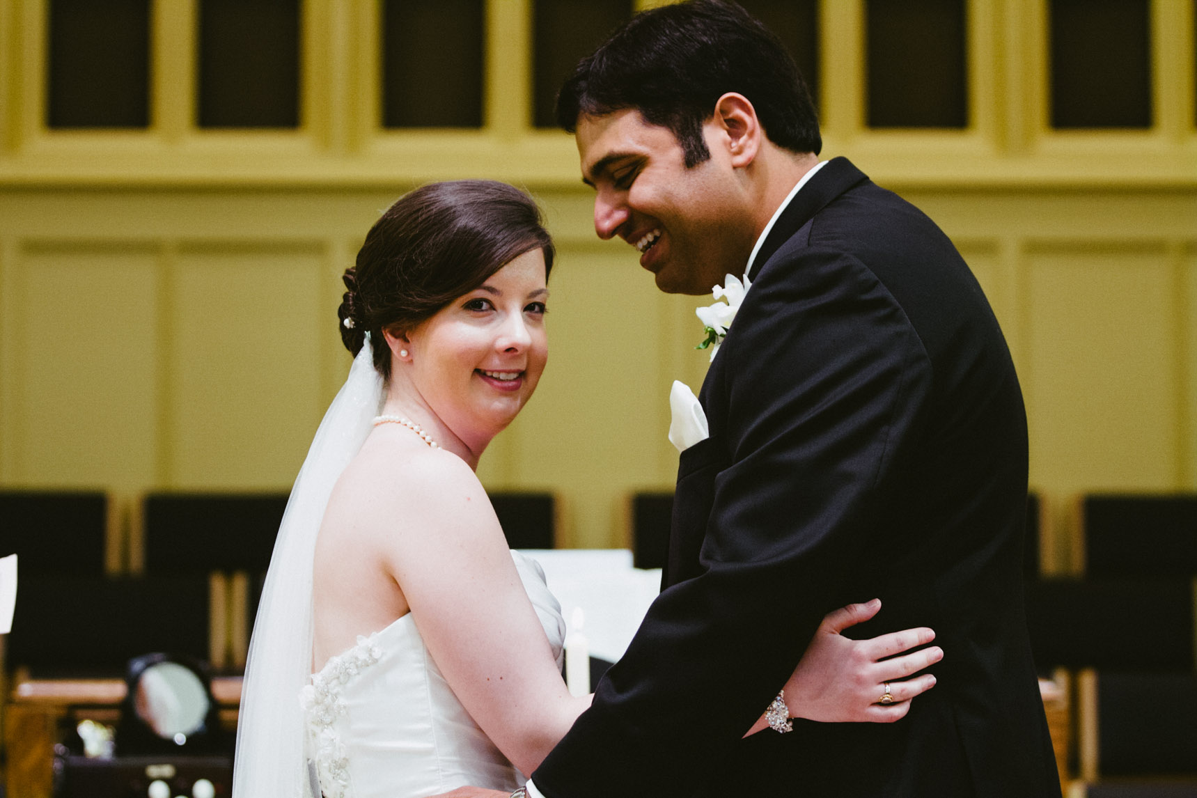 Bride and groom smiling after kiss.
