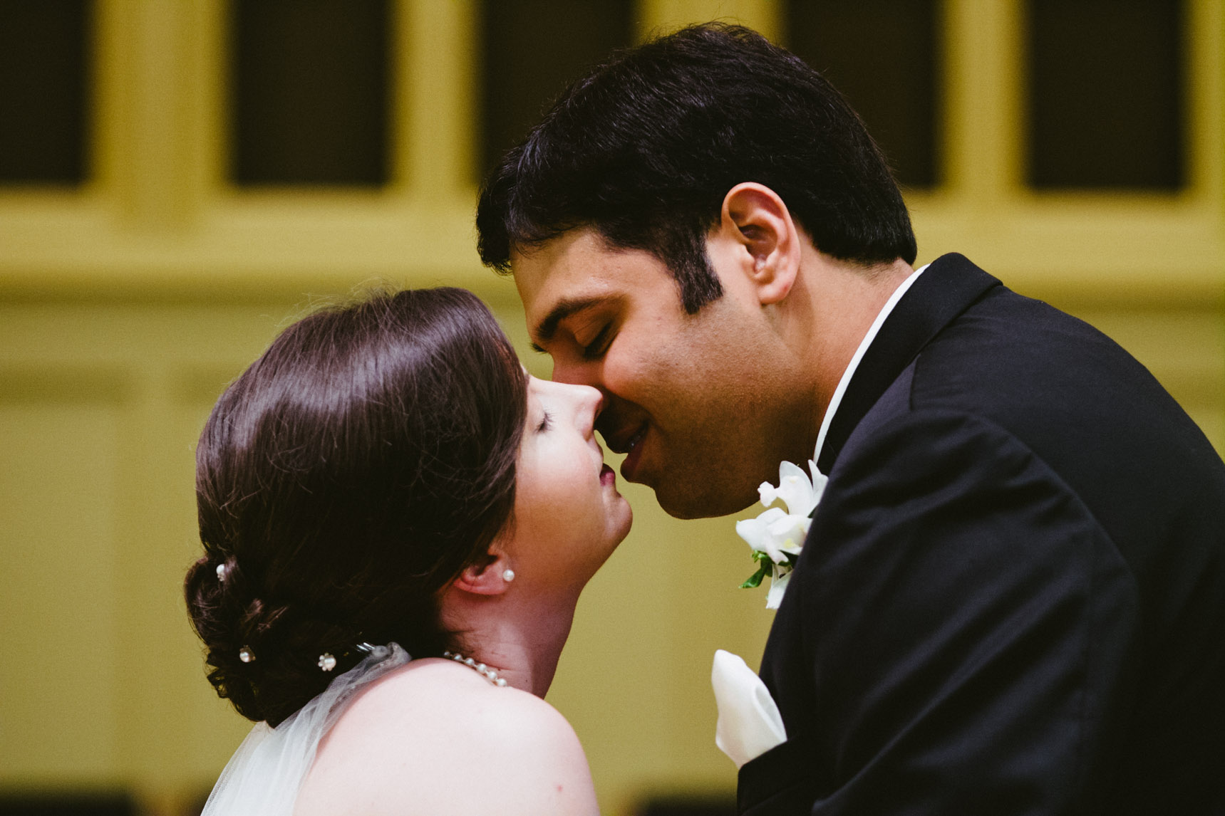 Bride and groom kiss during wedding ceremony.