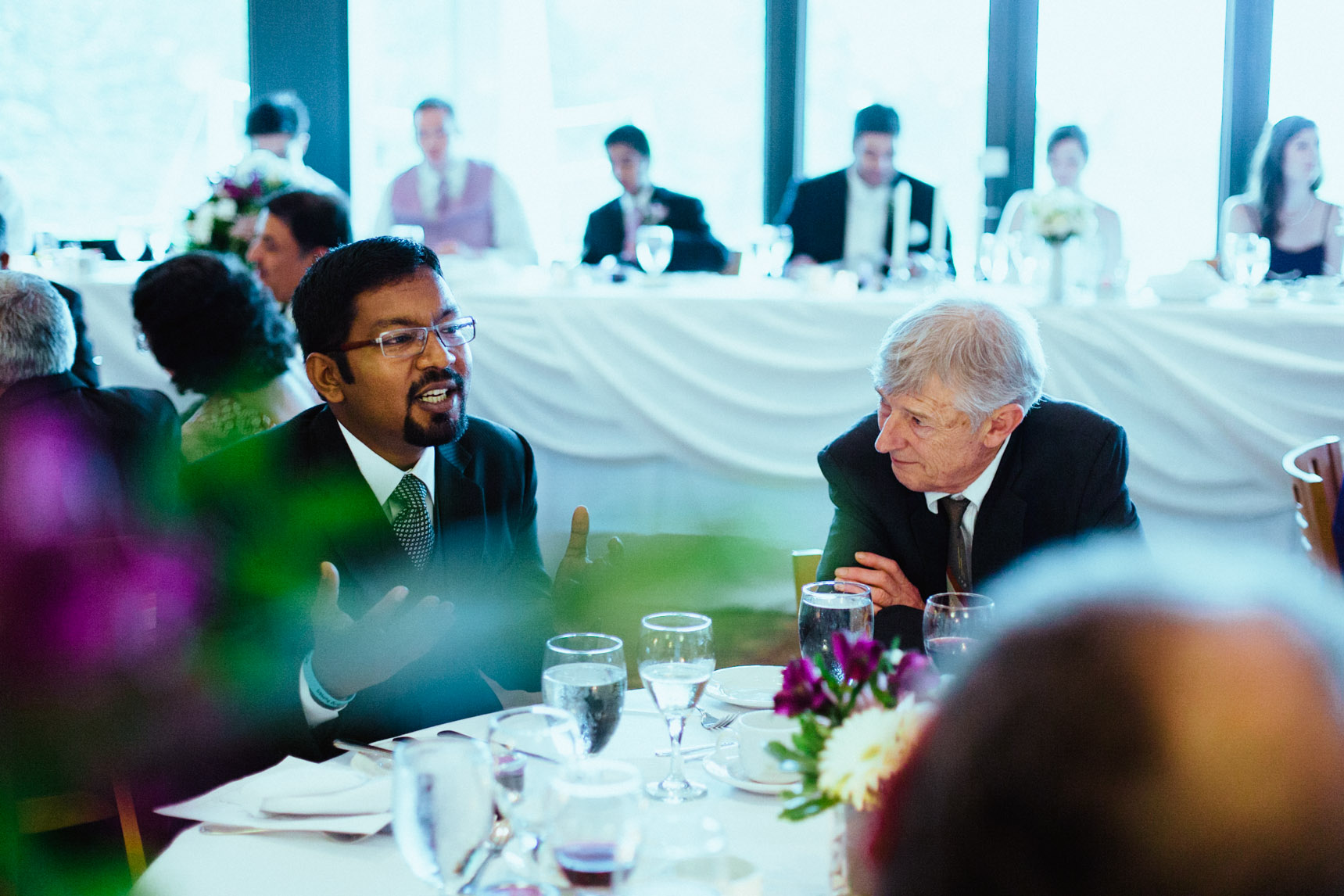 Wedding guests converse during dinner reception.