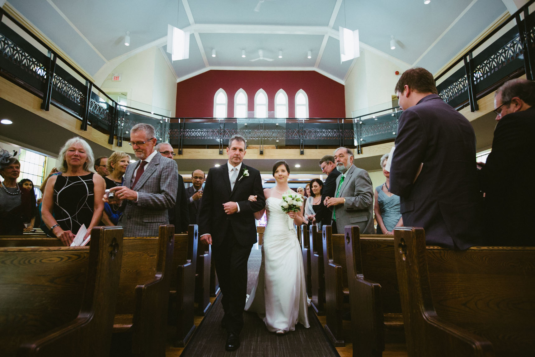 Father walks bride down the aisle of the Aurora United Church.