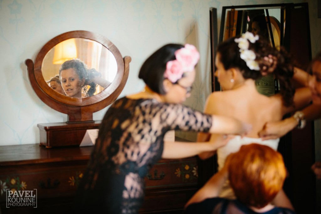 Intimate wedding photography: bride putting on dress