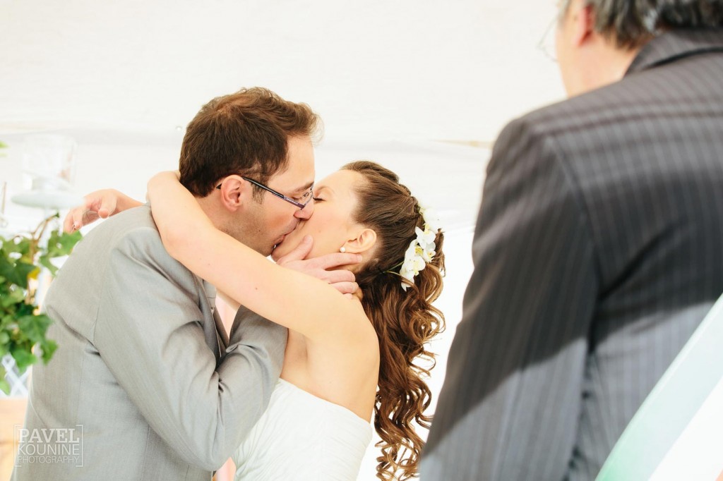 Intimate wedding photography: bride and groom kiss at ceremony